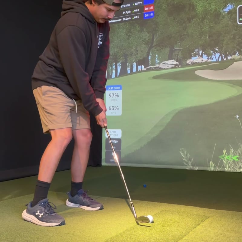 A golfer lining up a shot on the simulator at Birdie Lounge