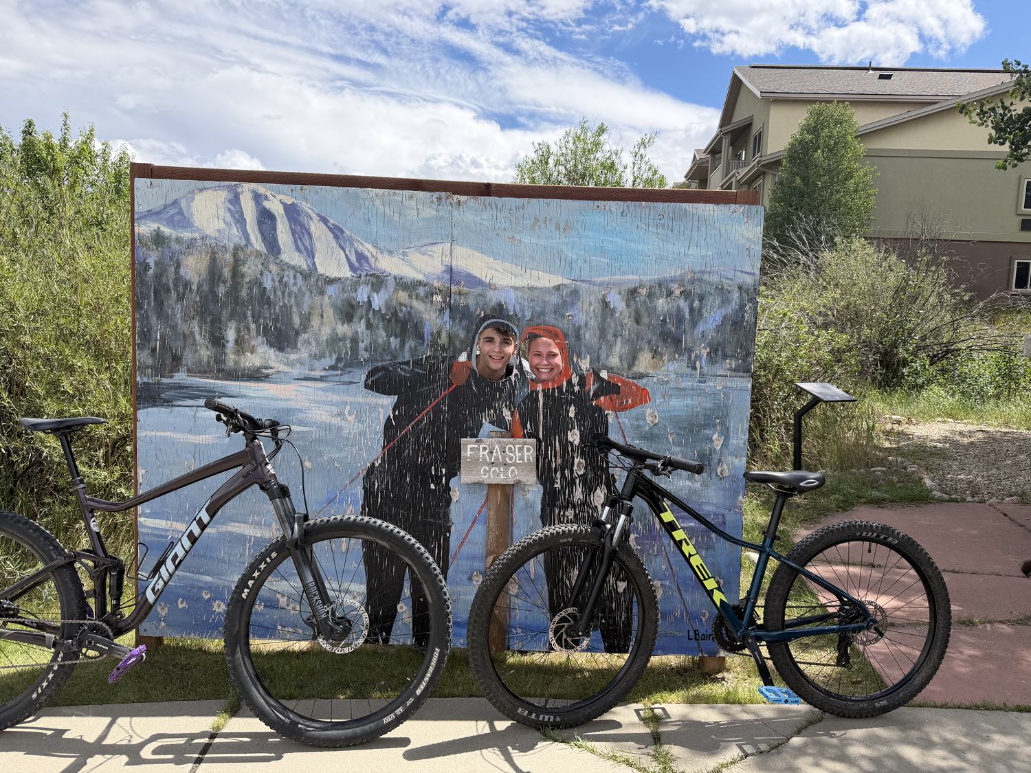 Two mountain bikes parked in front of a Fraser, Colorado mural